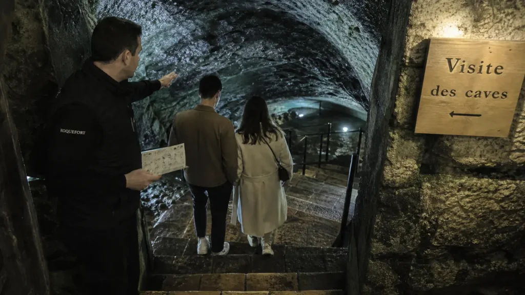 Visiter les caves de roquefort aveyron : guide vers l’escalier en pierre humide