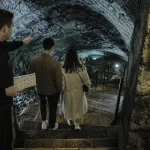 Visiter les caves de roquefort aveyron : guide vers l’escalier en pierre humide