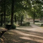 Camping rignac aveyron : emplacements ombragés, table et chemin vers la piscine